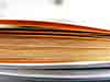 edge view photgraph of a stack of orange and yellow brochures
